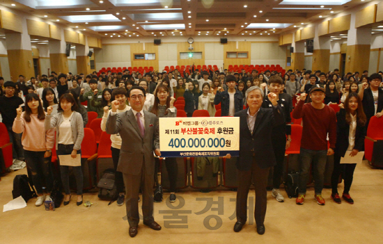 임상택 부산불꽃축제 조직위원회 집행위원장(팻말 왼쪽)과 조의제 비엔그룹·대선주조 회장(오른쪽)이 후원금 팻말을 들고 축제 자원봉사자들과 함께 파이팅을 외치고 있다./사진제공=비엔그룹<BR><BR>