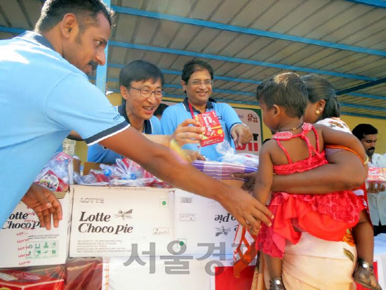 지난 20일 100년 만의 폭우로 400여명이 사망하고 176만명의 이재민이 발생한 인도 남부 타밀나두 지역에서 롯데제과 인도법인 직원들이 이재민들에게 롯데초코파이와 생수 등 식료품을 지원하고 있다./사진제공=롯데제과<BR><BR><span class='sub_ad_banner4'><div id='div-gpt-ad-1567043459465-0' ><script>googletag.cmd.push(function() { googletag.display('div-gpt-ad-1567043459465-0'); });</script></div></span>