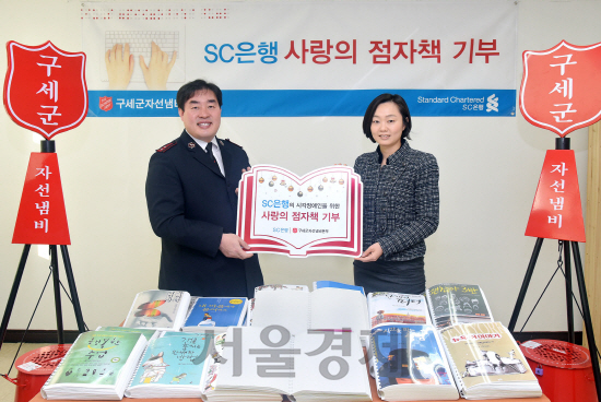 김미란(오른쪽) 한국스탠다드차타드(SC)은행 사회공헌담당 팀장이 22일 서울 서대문구 구세군회관에서 김기석 한국구세군자선냄비본부 모금실장에게 한국SC은행 임직원들이 제작한 점자책을 기부하고 기념촬영을 하고있다. 점자책은 전국 40개 점자도서관, 15개 시각장애인복지관, 13개 맹학교에 보급된다. /사진제공=한국SC은행<BR><BR><span class='sub_ad_banner4'><div id='div-gpt-ad-1567043459465-0' ><script>googletag.cmd.push(function() { googletag.display('div-gpt-ad-1567043459465-0'); });</script></div></span>