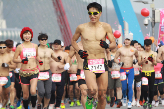 ‘2016 에코-사이언스 대전 알몸마라톤대회’ 참가자들이 윗옷을 벗은 채 힘차게 출발하고 있다, 이들은 갑천길 7㎞를 알몸으로 달렸다. 사진제공=맥키스컴퍼니<BR><BR>