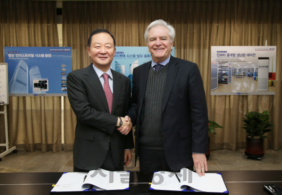 강성희(왼쪽) 오텍그룹 회장과 윌리엄 스트리베(William F. Striebe) UTC그룹 부사장이 22일 파킹시스템 공동사업 협약을 체결했다./사진제공=오텍그룹