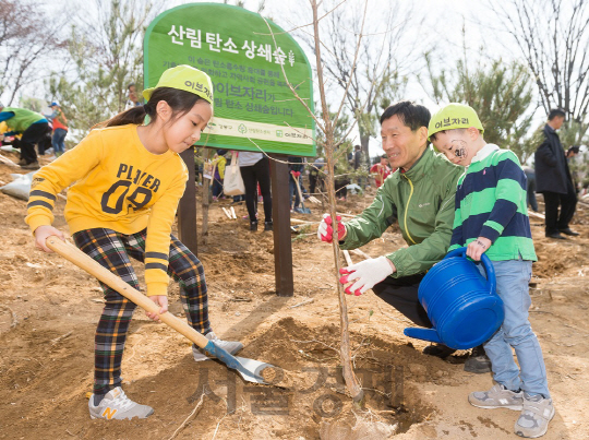 지난해 강동구 일자산도시자연공원에서 이브자리와 서울시가 공동으로 진행한 ‘탄소상쇄숲’ 조성행사에 참가한 가족이 나무를 심고 있다./사진제공=이브자리