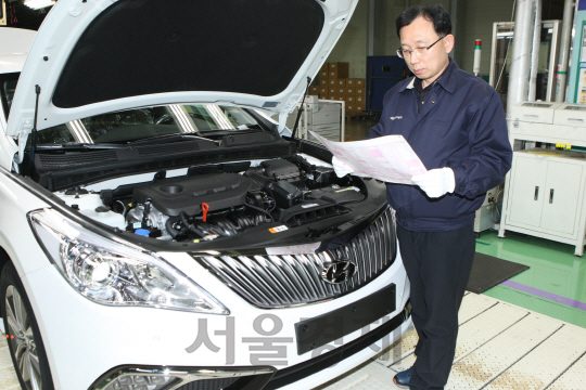 24일 현대자동차 아산공장 조립라인에서 30년간 그랜저를 생산해온 김창기 그룹장이 차량을 살펴보고 있다. /사진제공=현대차