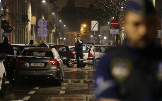 25일 벨기에 경찰이 브뤼셀 중부 외곽 지역에서 테러 용의자를 급습한 후 주변을 경계하고 있다. /브뤼셀=AP연합뉴스