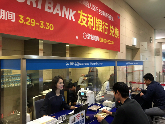 29일 인천 컨벤시아에 설치 된 우리은행 임시 환전소에서 중국인 관광객들이 환전을 하고 있다./사진제공=우리은행