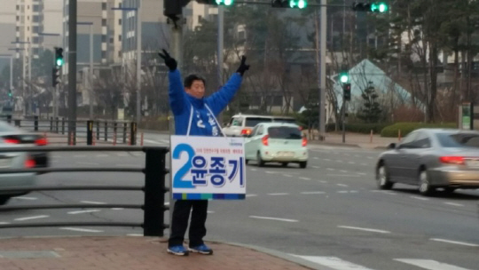 윤종기 더불어민주당 인천 연수을 후보가 횡단보도 앞에서 유권자를 향해 손을 흔들고 있다.