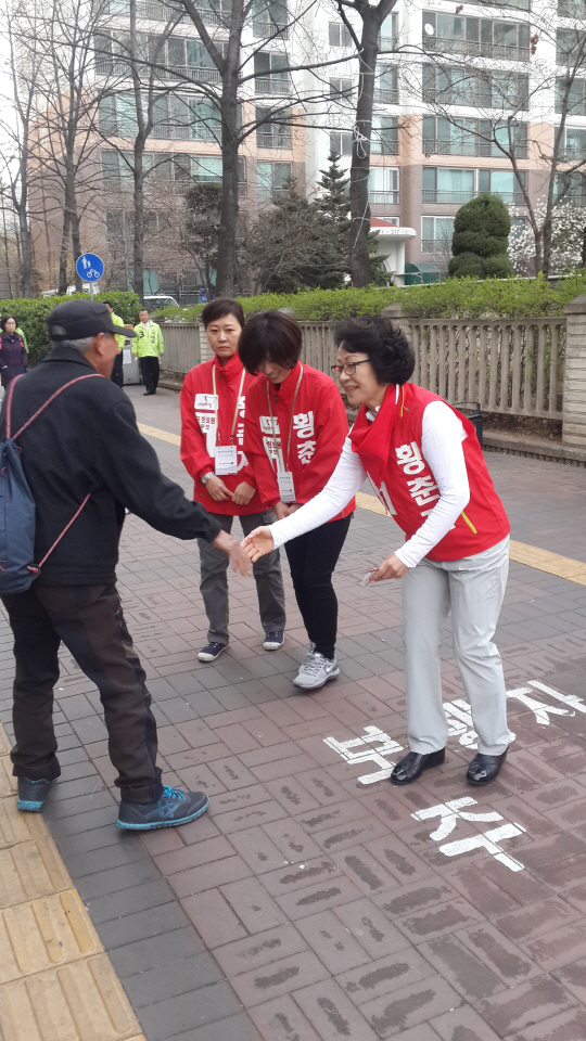 황춘자 새누리당 서울 용산 후보가 31일 이촌역 4번 출구 인근에서 한 유권자와 악수를 하고 있다.