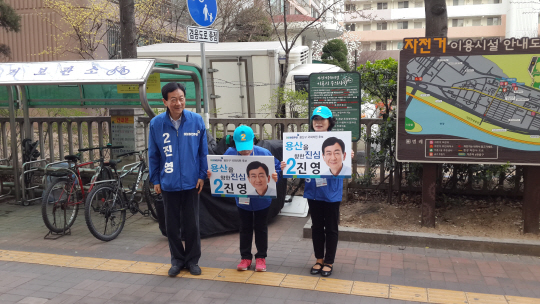 진영 더불어민주당 서울 용산 후보가 31일 이촌역 4번 출구 앞에서 선거운동원들과 함께 유권자에게 인사를 하고 있다.