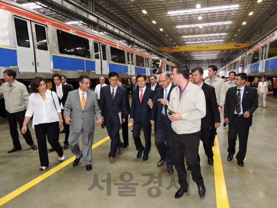 30일(현지시간) 브라질 상파울로주 아라라꽈라시에서 현대로템 철도챠량 공장 완공식이 열린 가운데 김승탁(앞줄 왼쪽 네번째) 현대로템 사장과 제라우두 아우키민(〃 〃 다섯번째) 상파울루 주지사, 마르셀로 바르비에리(〃 〃 두번째) 아라라꽈라시 시장 등 참석자들이 공장을 둘러보고 있다. 현대로템은 터키·미국에 이은 세번째 해외 생산기지인 브라질 기지를 1년만에 완공하고 연 8조원 규모의 중남미 철도 시장을 공략한다고 밝혔다. /사진제공=현대로템