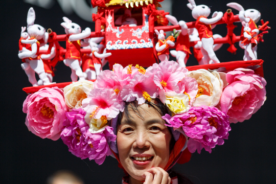 지난 3월 27일 뉴욕 맨해튼 부활절 모자 퍼레이드에 참여한 한 참가자가 화려한 장식으로 치장한 모자를 쓰고 웃고 있다. /신화 연합뉴스