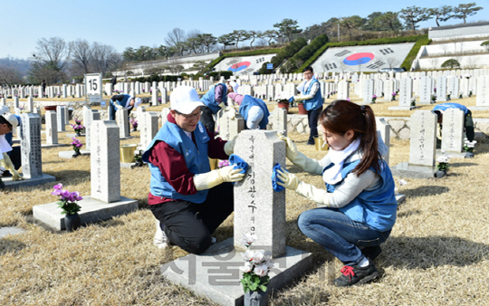 권오준(왼쪽)포스코회장이 1일 서울 동작구 국립현충원 15 및 17묘역에서 임직원들과 함께 묘비를 닦는 봉사활동을 펼치고 있다. /사진=포스코