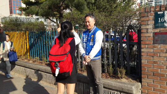 경기 용인정에 출마한 표창원 더불어민주당 후보가 1일 대현초등학교 앞에서 사진촬영을 요청하는 여학생과 이야기를 나누고 있다.