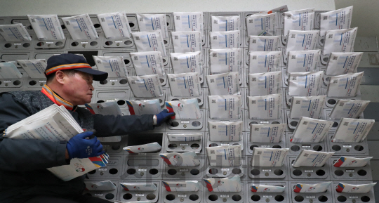 3일 오전 서울 마포구의 한 아파트에서 집배원이 제20대 국회의원선거 관련 선거공보물을 우편함에 넣고 있다./송은석기자