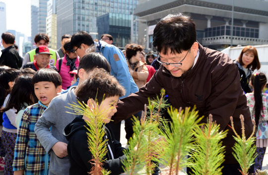 신원섭(앞줄 오른쪽) 산림청장이 식목일을 앞두고 지난달 23일 서울 광화문광장에서 열린 ‘국민과 함께하는 내 나무 갖기 한마당’ 행사에서 어린이들에게 나무를 나눠주고 있다. /사진제공=산림청
