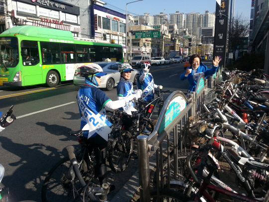 진선미(오른쪽) 더불어민주당 후보가 자전거 유세단과 함께 주민들에게 인사하고 있다. /박경훈기자