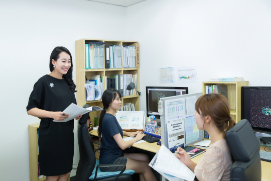 함시현 숙명여대 교수가 연구실 학생들에게 전산화학 연구 방법에 대한 설명을 하고 있다. 전산화학은 화학시료나 실험도구 대신 컴퓨터로 분자의 모델 등을 연구하는 학문이기 때문에 연구실 내의 컴퓨터와 관련 자료가 눈에 띈다. /사진제공=함시현 교수 연구실