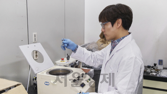 한국지질자원연구원의 최지혁 박사가 용액공정을 통해 나노입자가 코팅된 실리콘 가판을 들고 있다./사진제공=한국지질자원연구원