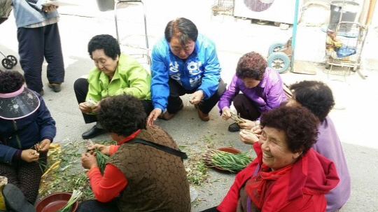 충북 청주상당에 출마한 한범덕(가운데) 더불어민주당 후보가 지난 6일 문의면 장터에서 주민들과 이야기를 나누고 있다.