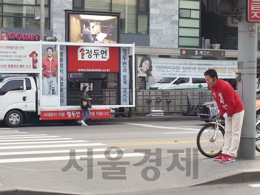 새누리당 정두언 후보가 12일 아침 서울 지하철3호선 홍제역 앞 거리에서 출근길 주민들에게 인사하는 모습. /박경훈기자