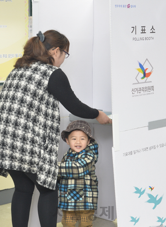 제20대 국회의원선거가 열린 13일 오전 서울 종로구 경운학교에 마련된 제20대 국회의원선거 투표소에서 투표하러 어머니와 함께 온 아기가 밝게 웃고 있다./송은석기자