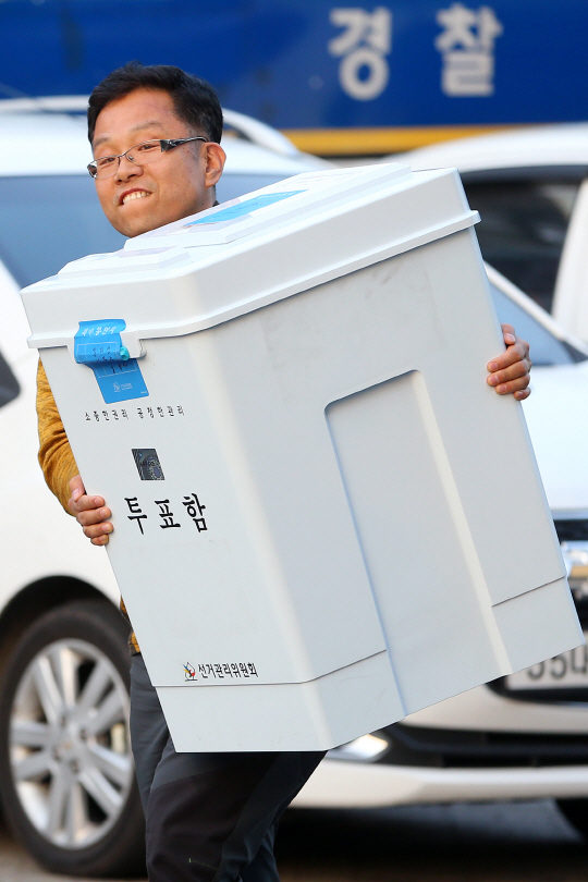 20대 총선 투표일인 13일 서울 송파구 올림픽공원 체조경기장에 마련된 개표소에서 한 선거관리원이 투표함을 옮기고 있다. /연합뉴스