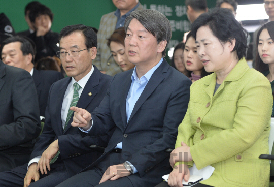 안철수 국민의당 상임공동대표가 13일 투표 여론조사결과 국민의당 지지율이 예상보다 높은것으로 나타나자 당지도부와 대화를 나누고 있다./송은석기자