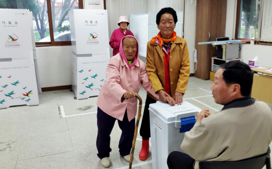 경상북도에서 가장 나이가 많은 유권자인 박분남(105·왼쪽) 할머니가 13일 오전 안동시 북후면 투표소를 찾아 투표를 하고 있다.  /안동=연합뉴스