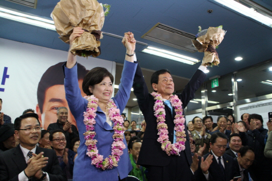 진영 더불어민주당 후보가 당선이 확정된 후 13일 서울 용산구 선거사무소에서 부인과 함께 꽃다발을 들어보이고 있다.
