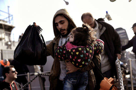 4일(현지시간) 그리스 레스보스섬 미틸리네에 도착한 한 난민이 아이를 안고 배에서 내려오고 있다./미틸리네=AFP연합뉴스