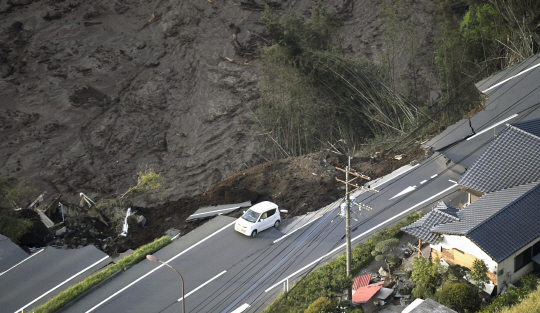 16일(현지시간) 새벽 발생한 규모 7.3의 2차 강진으로 일본 구마모토현 미나미아소에서 산사태가 발생해 도로가 무너져내린 가운데 승용차 한대가 남은 도로 끝에 위태롭게 걸려있다./AP=연합뉴스