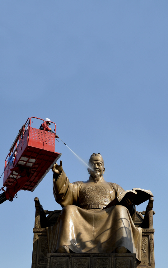 18일 오전 서울 세종대로 세종대왕상에서 작업자들이 크레인에 올라 동상 물청소를 하고 있다./송은석기자songthomas@sedaily.com