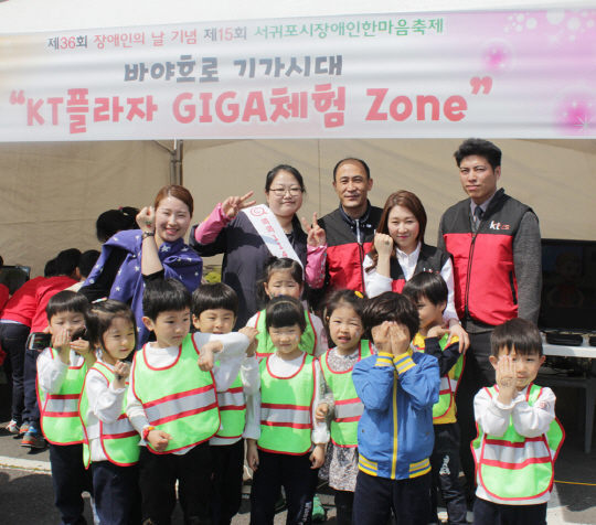 kt 컨설턴트들이 제주 서귀포시 장애인 한마음축제에서 페이스페인팅 재능기부를 한 뒤 어린이들과 자리를 함께 하고 있다. 사진제공= KT CS