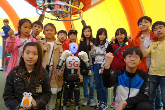 21일 봉동초등학교 어린이들이 전북 완주 소재 봉동초등학교에 설치된 티움 모바일에서 5G 로봇을 사전 체험하고 있다./사진제공=SK텔레콤