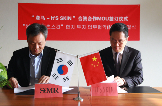 유근직(오른쪽) 잇츠스킨 대표가 21일 중국 상하이 썬마그룹에서 추지안창 썬마인베스트먼트 회장과 현지 합작회사 설립을 위한 업무협약 서류에 서명하고 있다. /사진제공=잇츠스킨