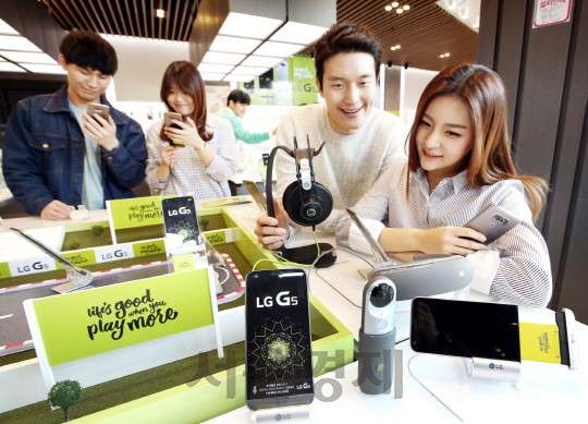 고객들이 서울 여의도의 한 이동통신매장에 전시된 LG전자의 전략 스마트폰‘G5’를 살펴보고 있다.  ‘G5’는 국내 출시 첫날인 지난달 말에만 1만 5,000대 이상 판매된 것으로 집계됐다. 사진제공/LG전자