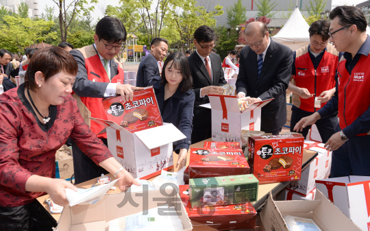 28일 서울 송파구 송파여성문화회관에서 롯데마트 주최로 열린 사회공헌 나눔확대 선포식에서 박향희(앞줄 왼쪽부터) 한백식품 대표, 김종인 롯데마트대표, 김근화 프레시벨 대표 등 참석자들이 청년 창업가 제품, 전통시장 상품, 우리 농가의 농산물 등으로 저소득층에 전해줄 ‘플레저박스(기쁨을 나누는 상자)’를 만들고 있다./송은석기자