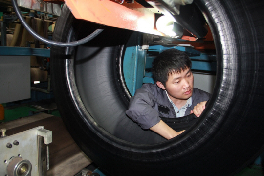 한국타이어 충칭공장 검사 라인에서 생산직원이 타이어 내부를 꼼곰히 점검하고 있다. /사진제공=한국타이어