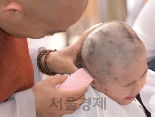 2일 오전 서울 종로구 조계사 대웅전 앞마당에서 열린 동자승 단기출가 보리수 새싹학교 삭발, 수계식에서 한 동자승이 얼굴을 찌푸리고 있다./송은석기자songthomas@sedaily.com