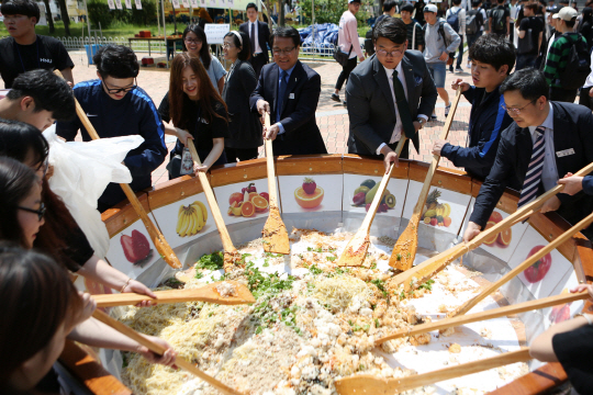 한남대 이덕훈 총장을 비롯한 이상호 총학생회장과 학생들이 ‘600인분 비빔밥’을 만들고 있다. 사진제공=한남대