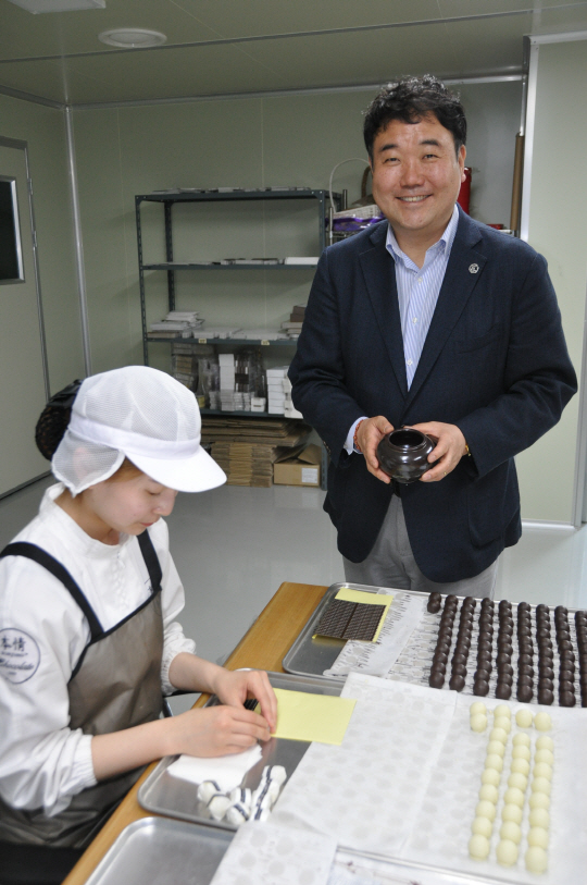 명품 초콜릿 전문기업 본정의 이종태 대표가 초콜릿 제품 포장에 쓰는 항아리를 들어 보이고 있다. /박희윤기자