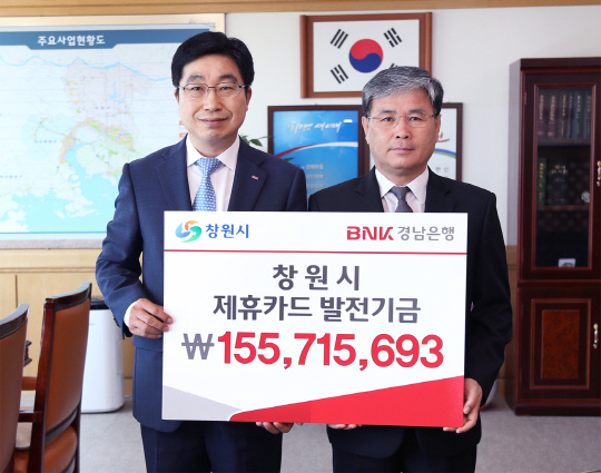 BNK경남은행 황윤철 부행장보(왼쪽)가 창원시 박재현 제1부시장에게 ‘창원시 제휴카드 발전기금 증서’를 전달한 후 기념촬영을 하고 있다. /사진제공=경남은행