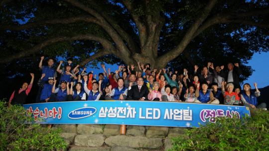 14일 삼성전자 강윤석 상무(앞줄 왼쪽에서 7번째) 황정수 무주군수(〃8번째) 등 호롱불마을 주민들과 삼성전자 임직원들이 점등식에 참석해 LED 보안등 설치를 축하하고 있다. /사진제공=삼성전자