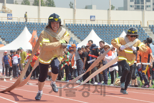 17일 오전 서울 목동운동장에서 열린 2016 서울시 의용소방대 종합소방기술경연대회 소방 호스 끌기 종목에 출전한 의용소방대원들이 소방호스를 어깨에 짊어지고 결승선을 향해 달리고 있다./송은석기자songthomas@sedaily.com