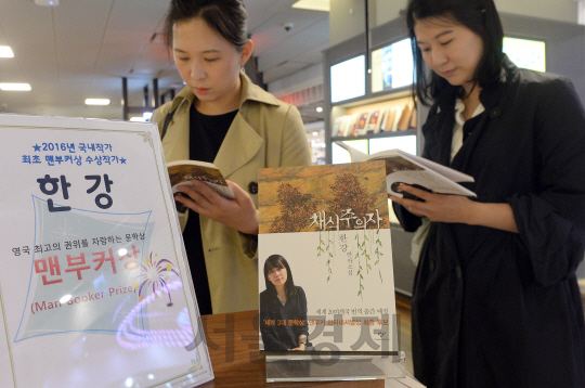 소설가 한강(46)이 세계3대 문학상인  맨부커상(Man Booker International Prize)을 수상한 다음날인 17일 한 독자가 광화문 교보문고에 전시되어 있는  '채식주의자' 를 탐독 하고 있다. '채식주의자'는 육식으로 상징되는 폭력을 거부하고 나무가 되길 원하는 30대 여성을 중심으로 한 세 편의 단편을 묶은 연작소설. 1월 영국에서 '더 베지터리언'(The Vegetarian)으로 출간된 뒤 해외 유수 언론으로부터 호평을 받았다./이호재기자.s020792@sedaily.com