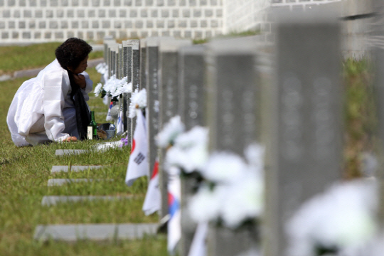 5·18 민주화운동 36주기을 하루 앞둔 17일 오전 광주 북구 운정동 국립 5·18 민주묘지에서 한 5월 유가족이 참배하고 있다./ 연합뉴스