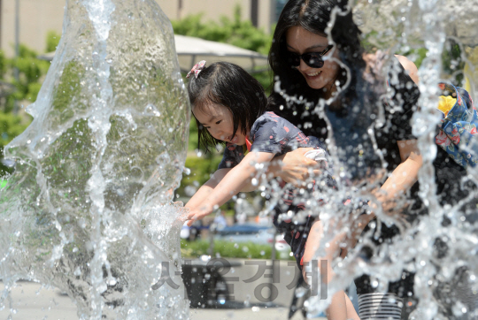 올해 첫 폭염주의보가 내려진 19일 서울 광화문광장에서 한 어린이가 엄마와 함께 물놀이를 하고 있다. 기상청은 낮 최고기온이 30도를 웃도는 이른 더위가 오는 24일까지 지속될 것으로 내다봤다./권욱기자 ukkwon@sedaily.com