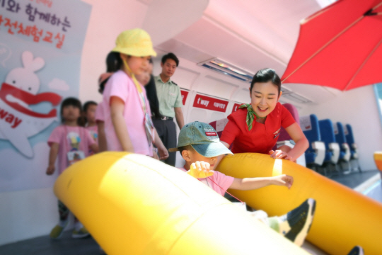 티웨이항공 승무원이 19일부터 열린‘서울 안전체험 한마당’의 체험 부스에서 어린이들이 비상상황을 가정해 슬라이드로 탈출하는 실습 과정을 돕고 있다. /사진제공=티웨이항공