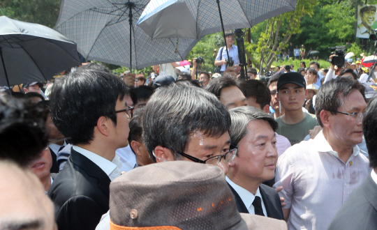 고(故) 노무현 전 대통령 서거 7주기 추도식이 열린 23일 오후 경남 김해 봉하마을 생태문화공원에서 국민의당 안철수 공동대표가 경찰이 곳곳에서 펼쳐 든 우산 아래에서 경호를 받으며 걷고 있다. /김해=연합뉴스