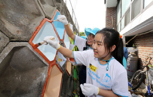 대우건설 임직원과 가족들이 성동구 마장동에서 환경개선을 위해 담벼락에 벽화를 그리는 봉사활동을 하고 있다./사진제공=대우건설