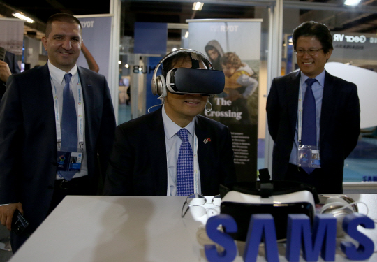김대현 (오른쪽)삼성전자 터키법인장이 지켜보고 있는 가운데 조윤수(가운데) 주터키 한국대사가 세계 인도주의 정상회의 가상현실(VR) 쇼케이스에서 삼성 기어 VR을 착용하고 VR 영상을 감상하고 있다. /사진제공=삼성전자